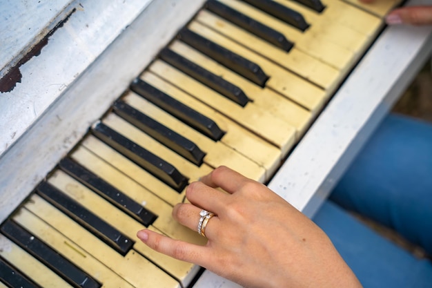 the hands of girl on the old piano keys Photo piano in retro style