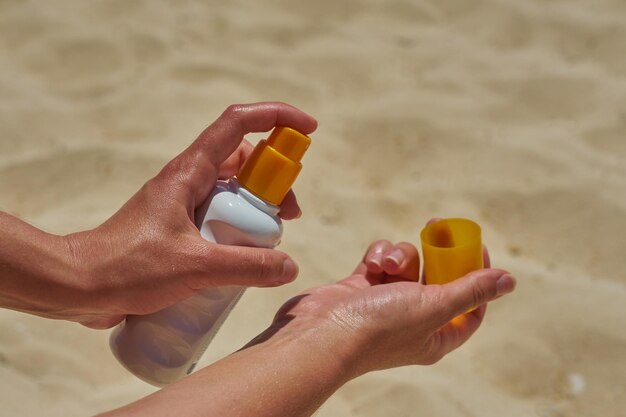 The hands of a girl who applies sunscreen