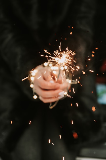 Hands of a girl with a sparkler close-up