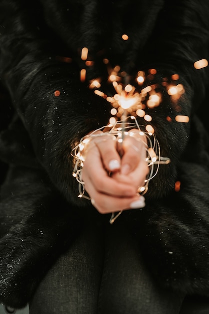 Hands of a girl with a sparkler close-up