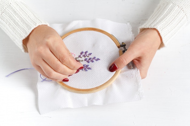 Hands of the girl working upon the embroidery