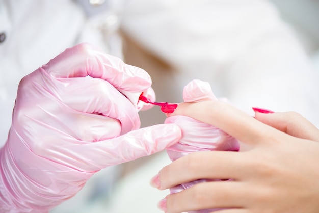 Hands in gloves cares about hand nails. Manicure beauty salon.