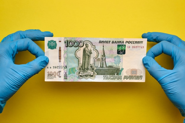 Hands in gloves hold banknote