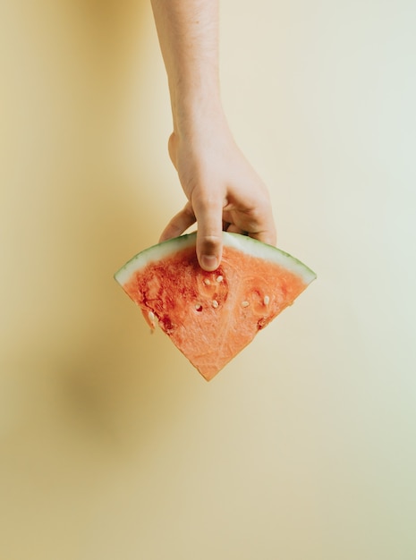 Photo hands grabbing a slice of watermelon top view mock up with copy space summer concept