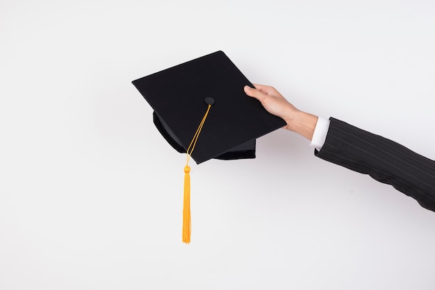 The hands of graduates holding a hat to throw a hat on isolated background.