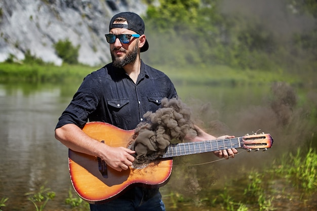 In hands guitarist guitar, of which there is smoke.