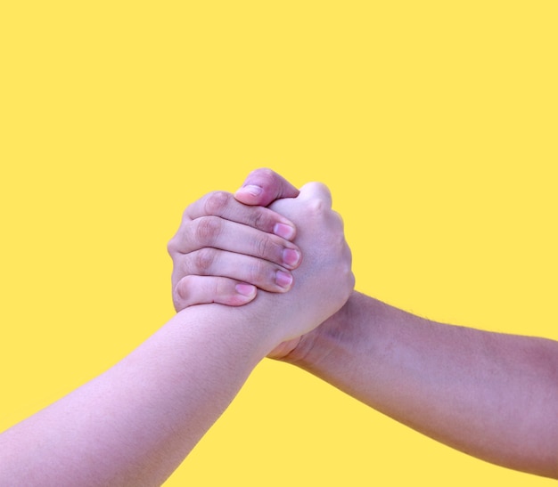 hands in handshake isolated on yellow.