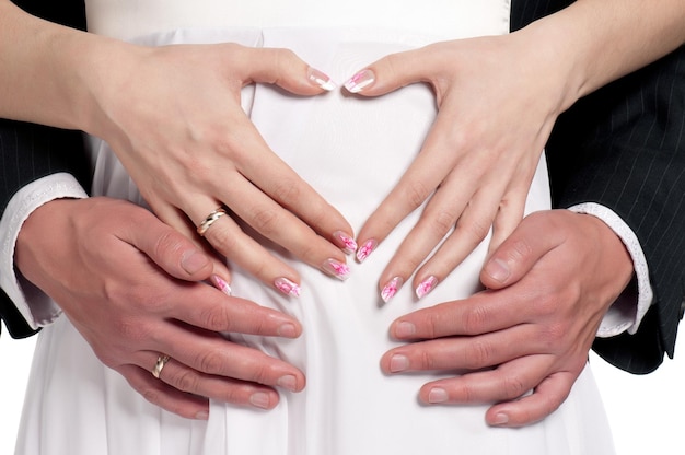 Hands of happy bride and groom with heart