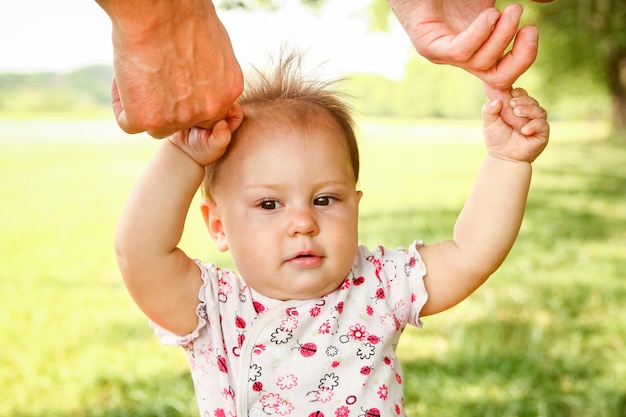 Hands of a happy parent and child in nature