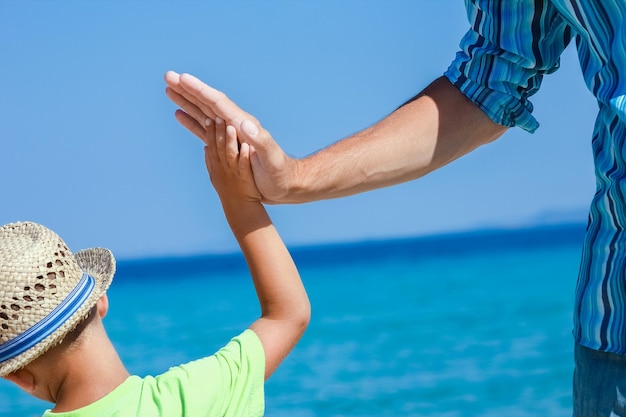 A Hands of a happy parent and child on the seashore on a journey trip in nature