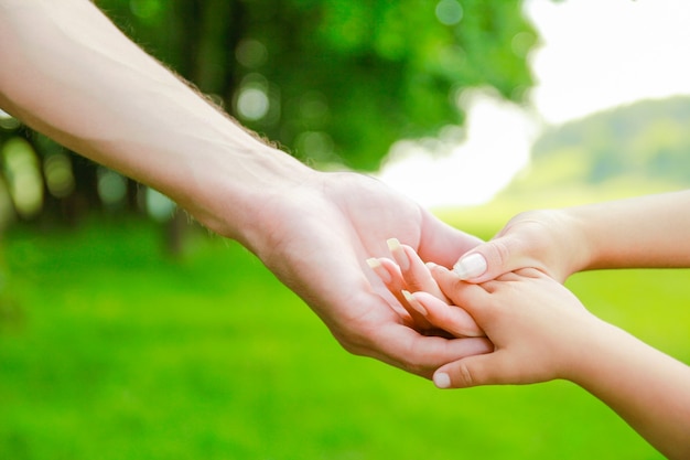 Mani genitori felici e bambino all'aperto nel parco