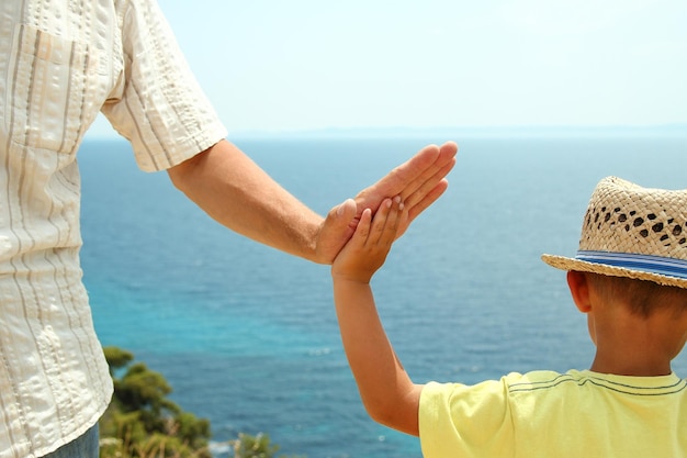 Руки счастливых родителей и детей в море на фоне путешествий по греции