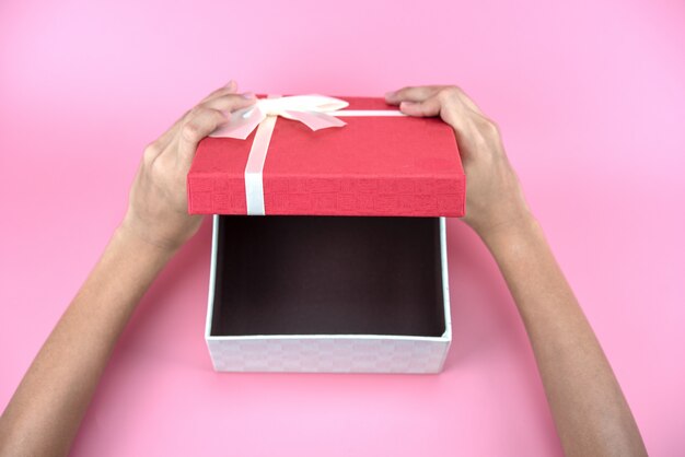 Hands hold a empty red and white gift box