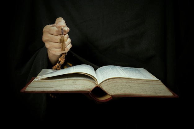 Photo hands holding bible and rosary