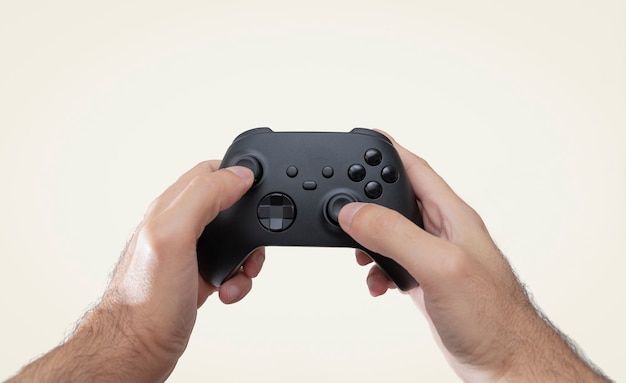 Hands holding black game controller isolated on white background