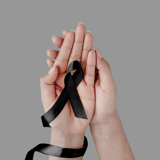Photo hands holding black mourning ribbon