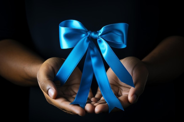 Hands holding a blue gift ribbon on black background closeup