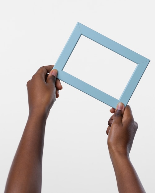 Hands holding blue wooden frame