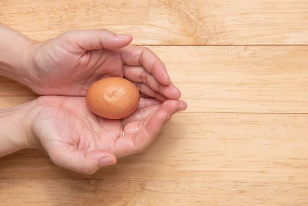 Hands holding a broken egg