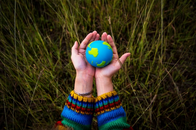 Foto mani che tengono un globo di argilla