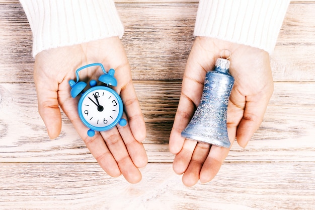 Hands holding a clock and Christmas ornament