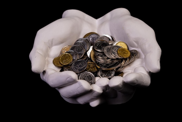 Hands holding coins selective and soft focus isolated on black background with copy space