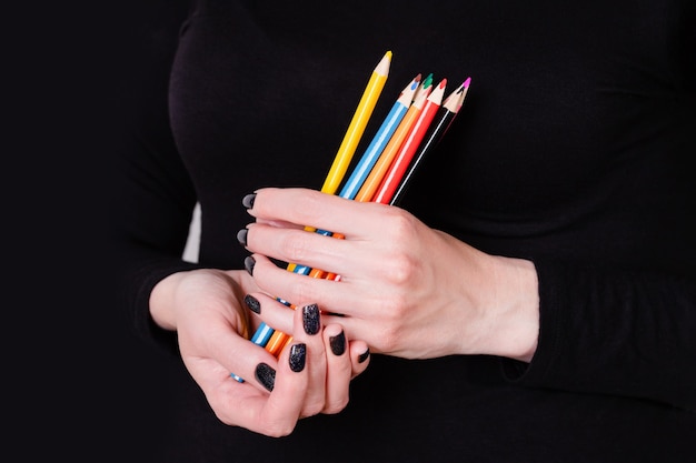 Hands holding colored pencils