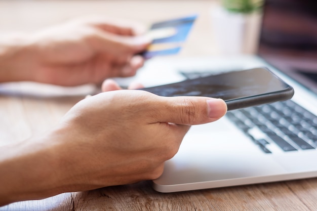 Hands holding credit card and smartphone