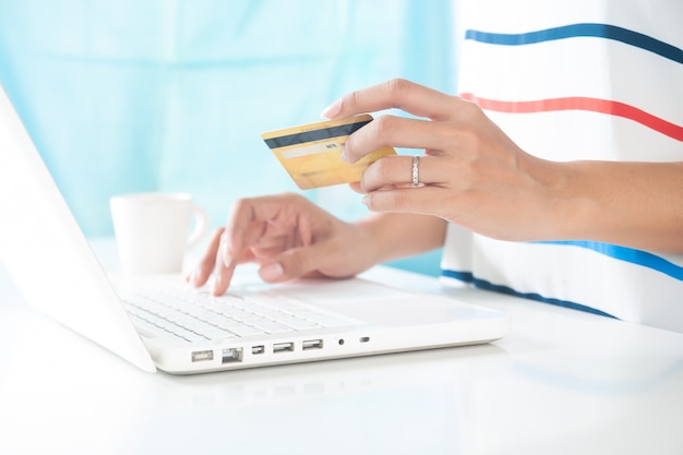 Photo hands holding credit card and using laptop computer. online shopping, e-payment or internet banking