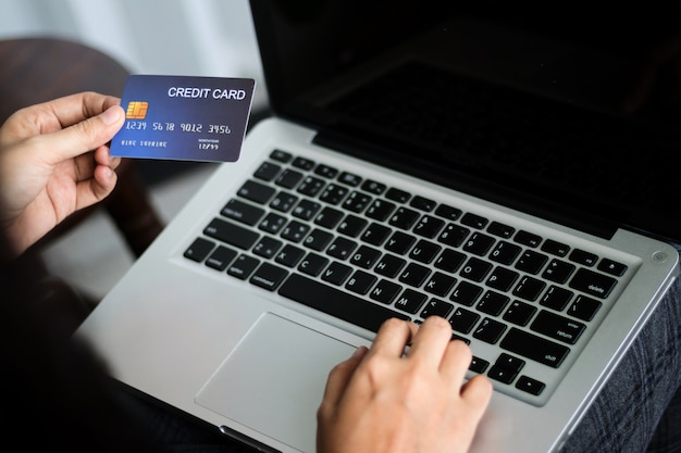 Photo hands holding credit card and using laptop. online shopping. copy space.