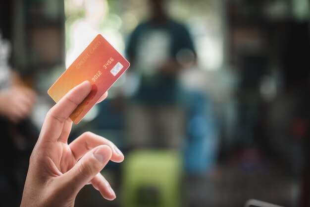 Foto mani che tengono una carta di credito e usano un portatile per fare acquisti online