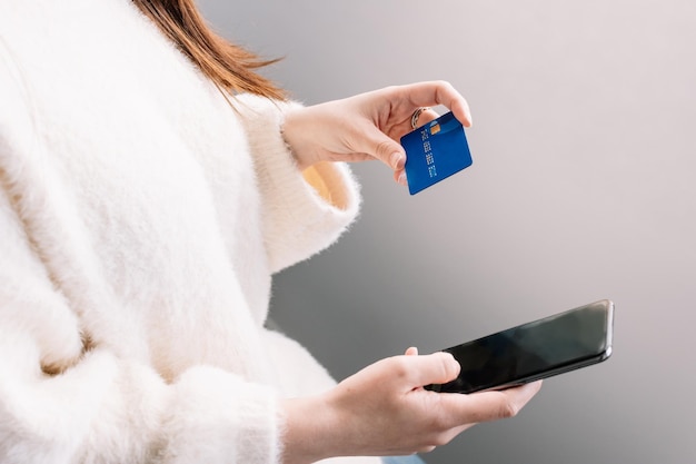 Hands holding credit card and using the smartphone Online shopping