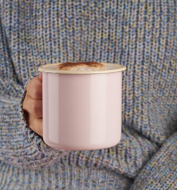 Hands holding cup of hot chocolate, gray cozy sweater, beautiful pink manicure, home style