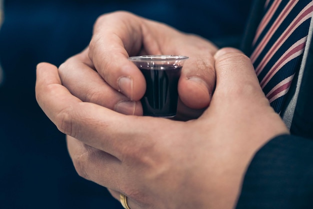 Foto mani che reggono una tazza di liquido con su scritto 