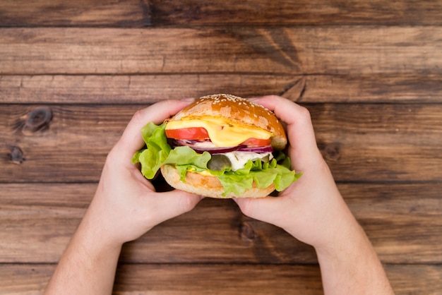 Hands holding a delicious burger