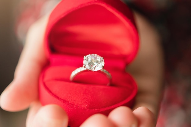 Hands holding diamond ring in jewelry box