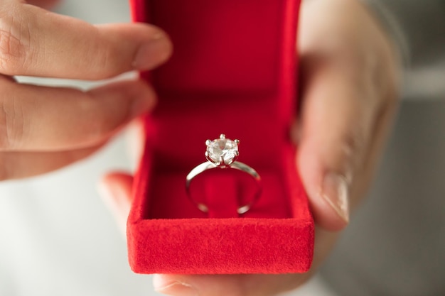 Hands holding diamond ring in jewelry box