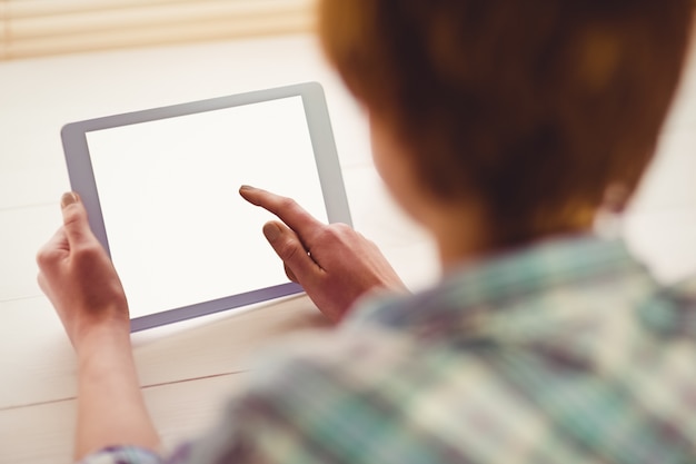  Hands holding digital tablet by coffee cup on table