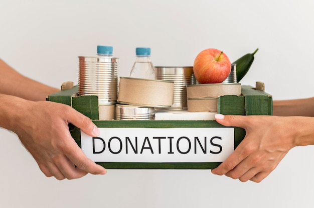 Photo hands holding donation box with food