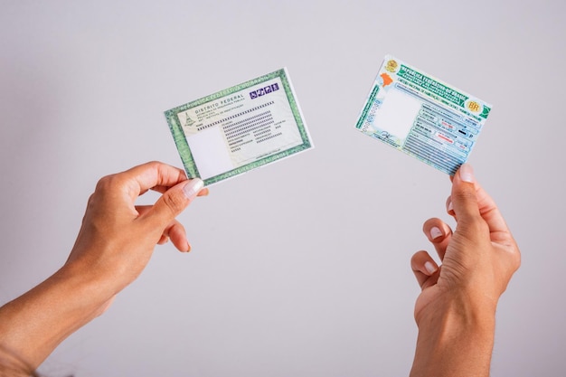 Hands holding driver's license and identity card Brazilian documents