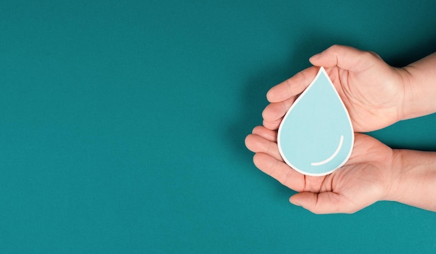 Hands holding a drop of water, paper cut out, environmental issue, world water day