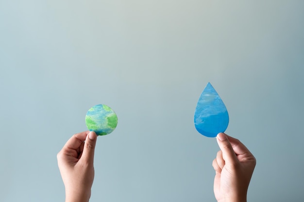 Hands holding earth and water drop concept of save water save the world