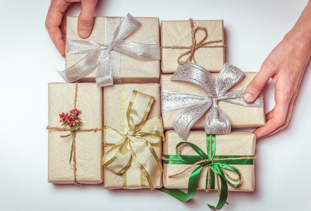 Hands holding gifts on a white background.