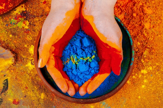 Hands holding Holi powder paint, view from above