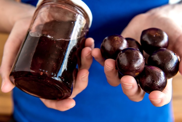 Hands holding homemade organic jabuticaba jelly with exotic Brazilian fruits, Jaboticaba is a common fruit in South America