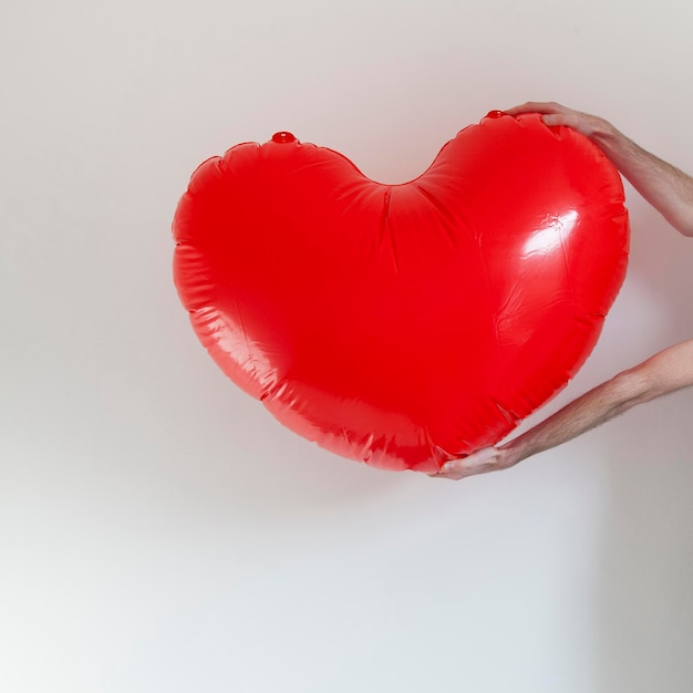 Hands holding a large inflatable heart shape