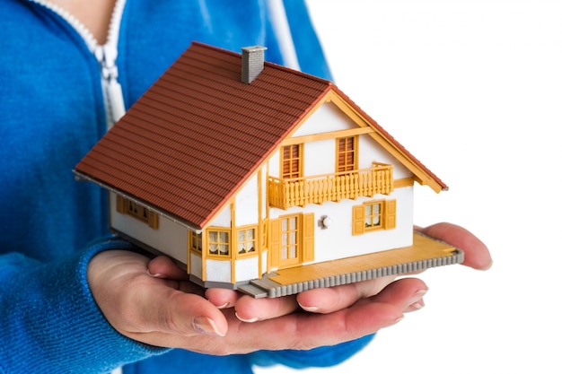 Hands holding miniature house model