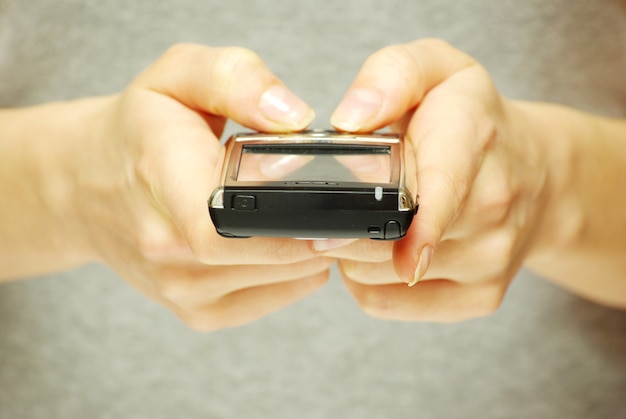 A hands holding a mobile phone for support