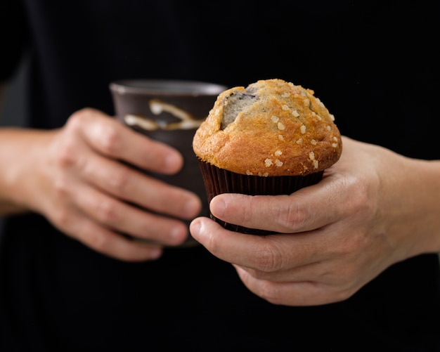 Hands holding a muffin look delicious. 