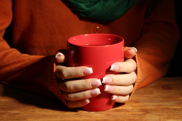 Hands holding mug of hot drink, close-up